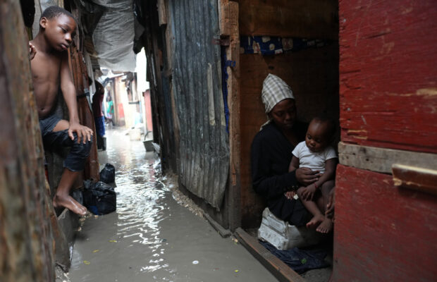 People stay inside a shelter for families displaced by gang violence, flooded by rain brought by Hurricane Melissa, in Port-au-Prince, Haiti, Wednesday, Oct. 29, 2025. (AP Photo/Odelyn Joseph)